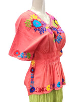Colorful outfit with a pink top and green skirt on a mannequin against a white background